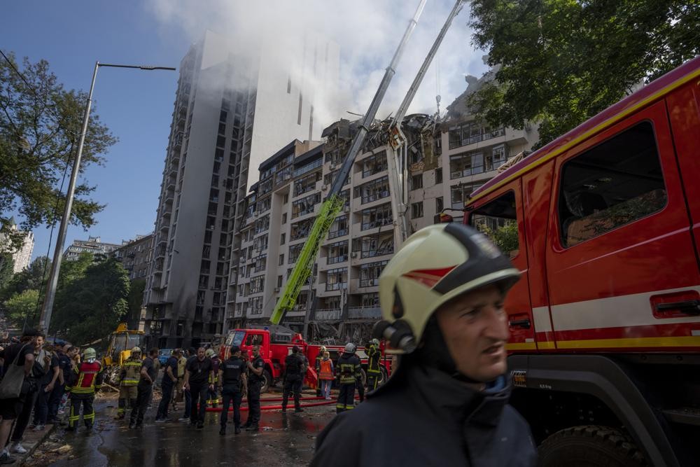Firefighters work at the scene of a residential building following explosions, in Kyiv, Ukraine, Sunday, June 26, 2022. Several explosions rocked the west of the Ukrainian capital in the early hours of Sunday morning, with at least two residential buildings struck, according to Kyiv mayor Vitali Klitschko. (AP Photo/Nariman El-Mofty)